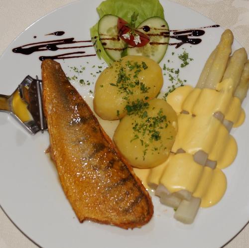 a plate of food with fish and potatoes and vegetables at Landhotel Jungbrunnen in Bad Brambach