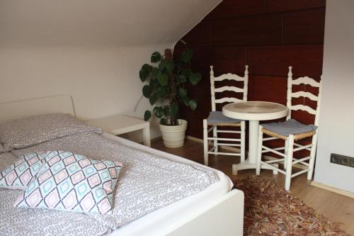 a bedroom with a bed and two chairs and a table at Zimmer David in Cologne