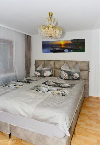 a bedroom with a large bed with a chandelier at Ferienwohnung Seestern in Schluchsee