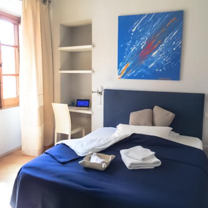a bedroom with a blue bed with towels on it at Numero 3 in Cagliari