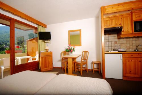 a room with a kitchen and a table with a tableablish at Résidence La Rochetaillée in Brides-les-Bains