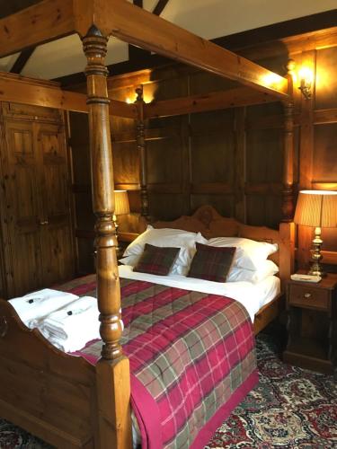 um quarto com uma cama grande e uma estrutura em madeira em The Stables at Whaplode Manor em Holbeach