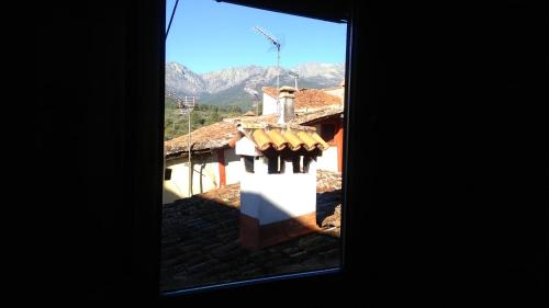 a view of a house with mountains in the background at La Solana, alojamiento y alfarería in Arenas de San Pedro