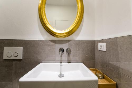 a bathroom with a white sink and a mirror at B&B Pizzeria Zur Traube in Montagna