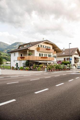 a large building on the side of a road at B&B Pizzeria Zur Traube in Montagna