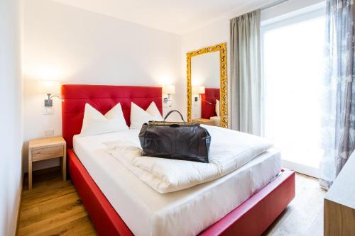 Un dormitorio con una cama grande con una bolsa negra. en B&B Pizzeria Zur Traube, en Montagna
