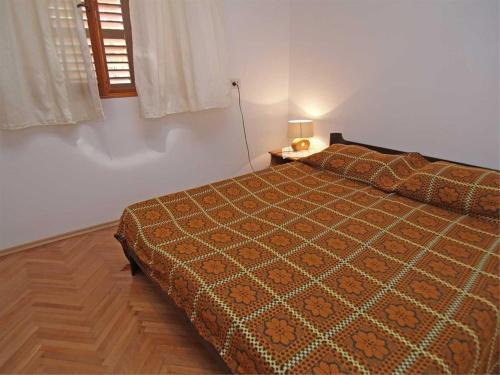 a bedroom with a bed and a table and a window at Anastasia 1 in Veli Lošinj