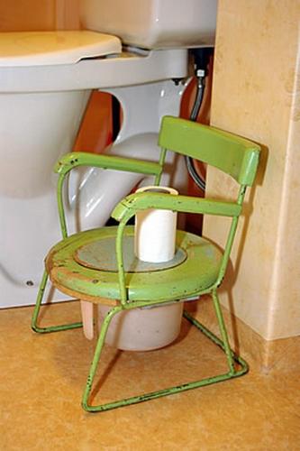 a green chair sitting in front of a sink at Smultronboda Fårgård in Edsbruk