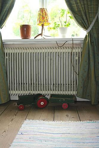 a toy radiator sitting in front of a window at Smultronboda Fårgård in Edsbruk