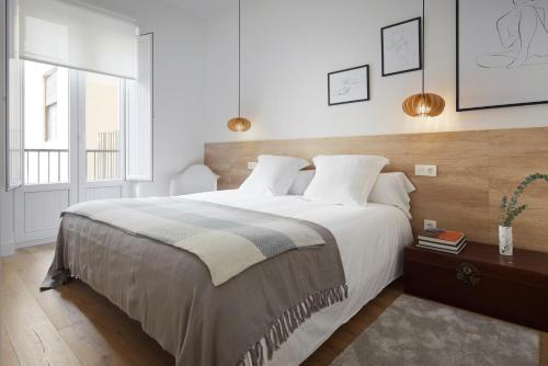 サン・セバスティアンにあるMiramon by FeelFree Rentalsのベッドルーム1室(大型ベッド1台、ペンダントライト2つ付)