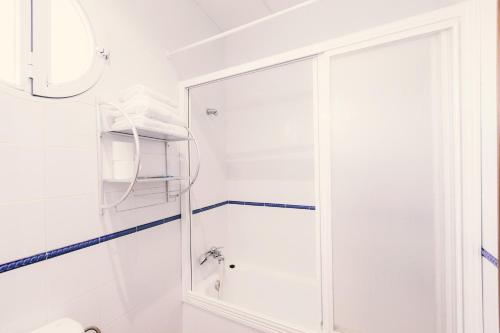 a white shower with a glass door in a bathroom at Hostal La Dehesa in Villanueva del Rey