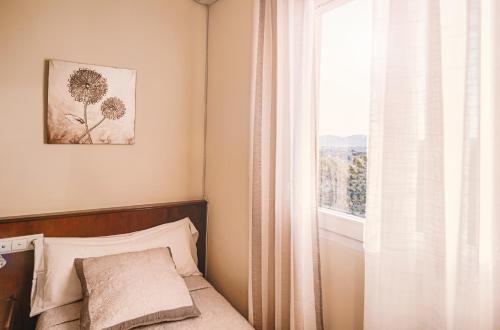a bedroom with a bed and a window at Hostal La Dehesa in Villanueva del Rey
