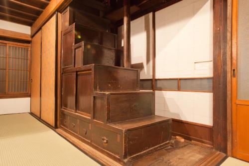 an empty room with an open door and a wooden door at Guest House Kura in Suzaka