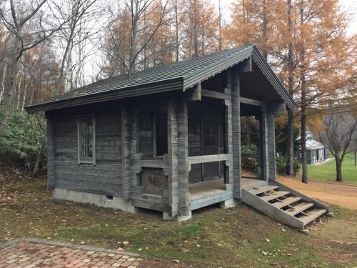 a small wooden building with a porch in a park at Auto Resort Takino in Sapporo