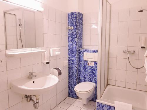 a bathroom with a sink and a toilet and a shower at Hotel Dormir in Moers