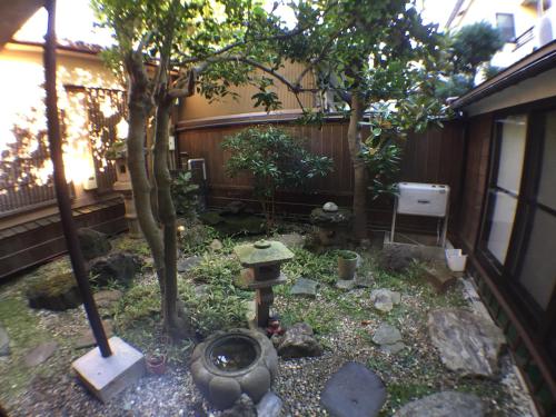 a garden with a fire hydrant and a tree at Kadokyu Ryokan in Takaoka