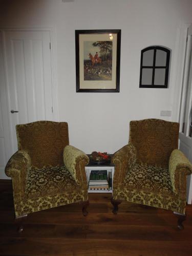 two chairs sitting in a living room with a table at B&B De Willemshoeve in Wageningen