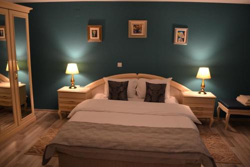 a bedroom with a large bed with two lamps at Casa Krone - Piața Sfatului in Braşov