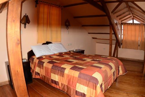 sypialnia z dużym łóżkiem na poddaszu w obiekcie Departamentos Cusco w Cuzco