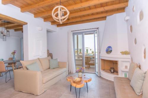 a living room with a couch and a fireplace at Salinus Beachfront Private Pool Villas in Plaka