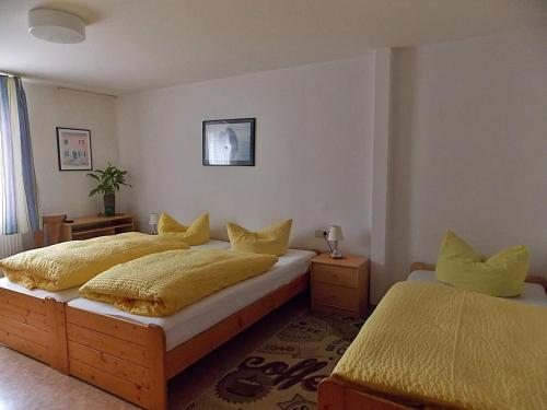 a bedroom with two beds with yellow pillows at Gasthof Goldener Stern in Aalen
