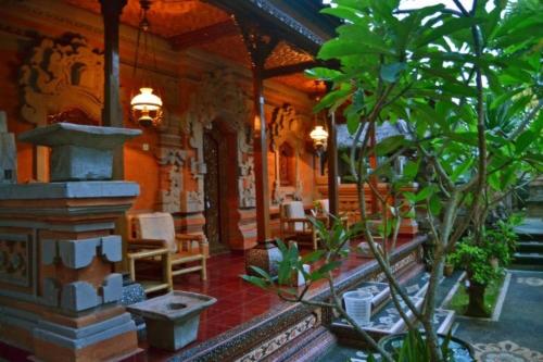 a room with chairs and plants in a building at Nyoman Murjana Homestay in Ubud