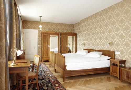 a bedroom with a bed and a table and a desk at Hotel Waldhaus Sils in Sils Maria