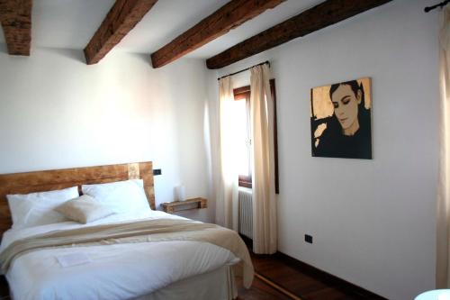 1 dormitorio con 1 cama y una pintura en la pared en Ai Sognatori, en Venecia