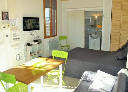 um pequeno quarto com uma cama, uma mesa e cadeiras em Studio RIGA em Ax-les-Thermes