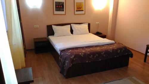 uma cama com lençóis brancos e almofadas num quarto em Vila Montana em Constança