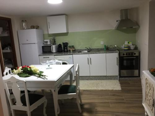 a kitchen with a white table with flowers on it at Quinta da Cartida in Santa Marinha do Zêzere