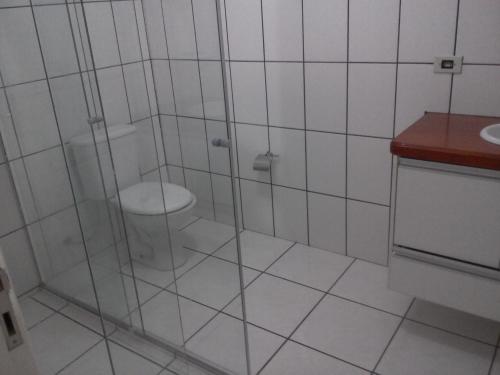 een badkamer met een douche, een toilet en een wastafel bij Casa sobrado in Campos do Jordão