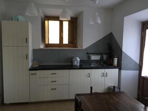 a kitchen with white cabinets and a counter top at Podere Telesforo in Acquapendente