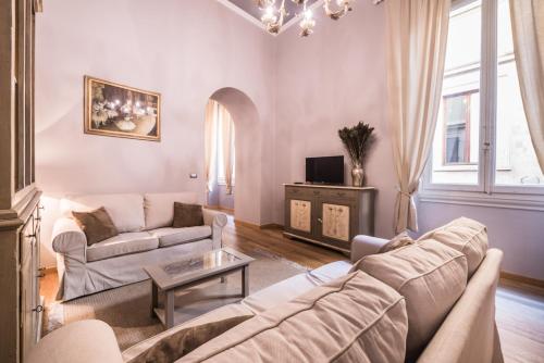 a living room with a couch and a table at Stunning Apt 5min Walk to Duomo in Florence