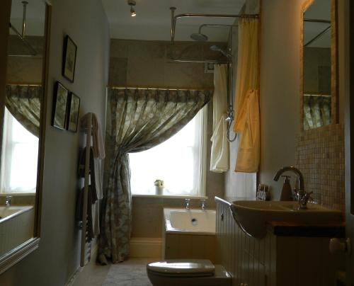 a bathroom with a sink and a toilet and a window at Riverview Apartment in Ripon