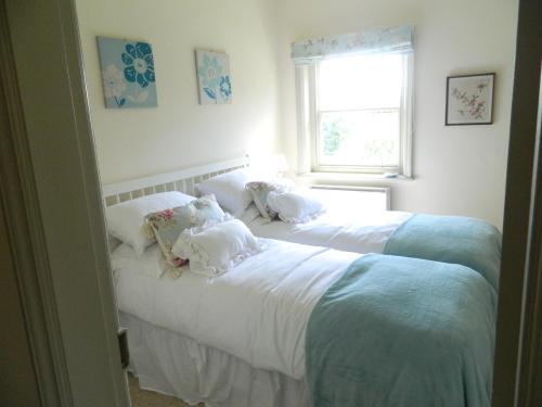 2 camas individuales en un dormitorio con ventana en Riverview Apartment, en Ripon