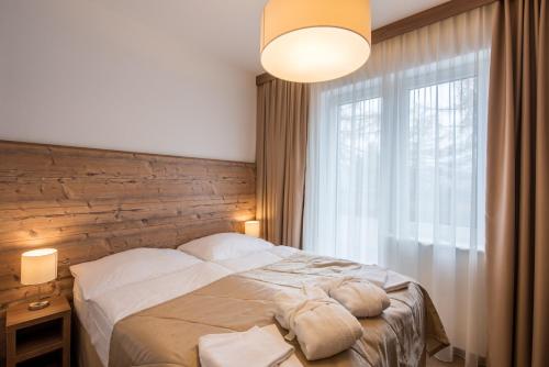 a bedroom with a large bed and a large window at Šport Hotel *** Donovaly in Donovaly
