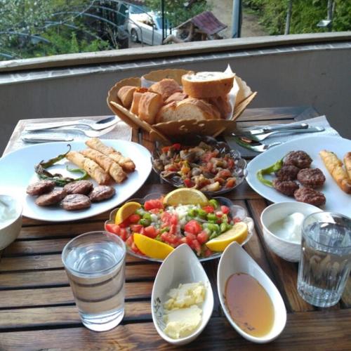 a wooden table with plates of food on it at Zirve Dağ Evi in Kocaeli