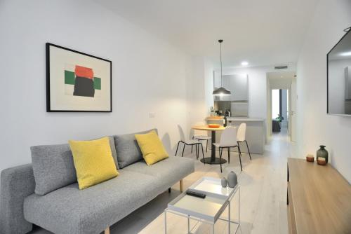 a living room with a couch and a table at Aspasios Atocha Apartments in Madrid