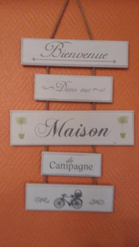 a group of four signs hanging on a wall at Domaine des Charmilles in Mantenay-Montlin