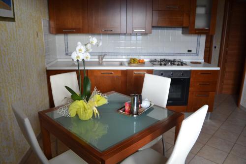 una cocina con una mesa con un jarrón de flores. en Appartamento panoramico, en Pancole