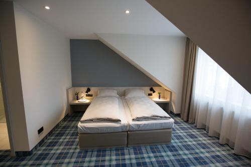 a bed in a room with an attic at Hotel Haberkamp in Achim