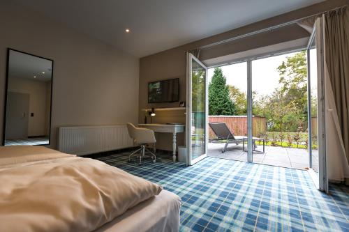 a hotel room with a bed and a sliding glass door at Hotel Haberkamp in Achim