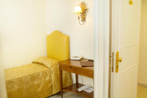 a room with a desk and a yellow chair at Hotel Lanzillotta in Alberobello