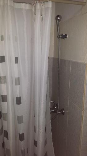 um chuveiro com uma cortina de chuveiro branca na casa de banho em Residencialdes em São Tomé