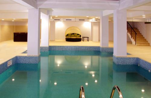 a pool with a bed in the middle of a building at Hotel King in Târgovişte