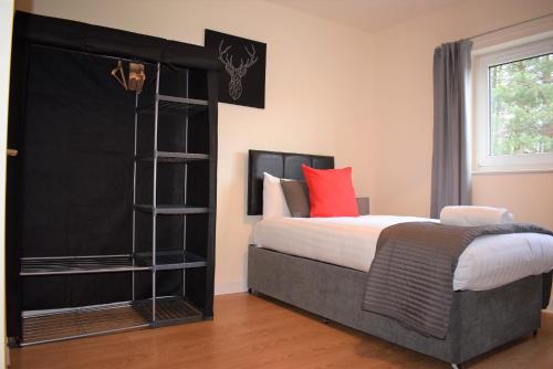 um quarto com uma cama e uma estante de livros em Kelpies Serviced Apartments Callum- 3 Bedrooms- Sleeps 6 em Livingston