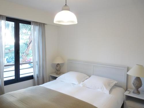 une chambre blanche avec un lit et une fenêtre dans l'établissement Elegant two bedroom apartment with modern design and terrace close to beaches and Cannes center 546, à Cannes