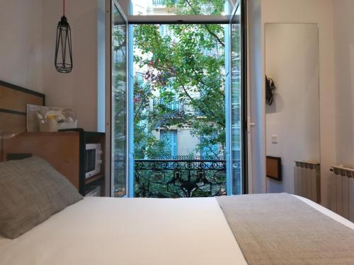 a bedroom with a bed and a large window at Pensión La Perla in Donostia-San Sebastián