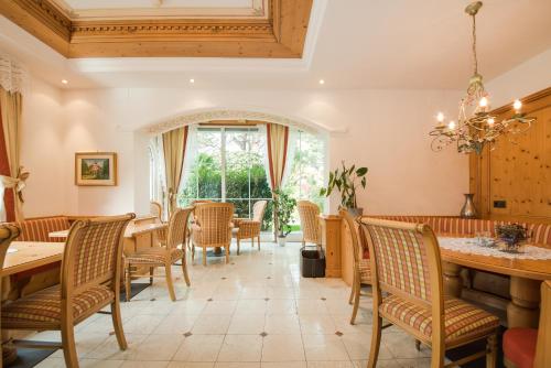 une salle à manger avec des tables et des chaises ainsi qu'une fenêtre dans l'établissement Hotel Salgart, à Merano